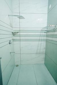 a white shower with a glass door in a bathroom at Mermaid Marari in Mararikulam