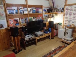 a living room with a flat screen tv and speakers at Premium Guest House Alaskan Dream in Akiota