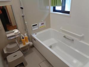 a white bathroom with a tub and a sink at Premium Guest House Alaskan Dream in Akiota +80 photos