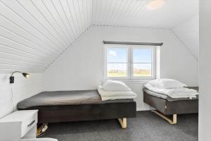 deux lits dans une chambre blanche avec une fenêtre dans l'établissement LF14145-Spottrup-Uglkaeret-5, à Spottrup