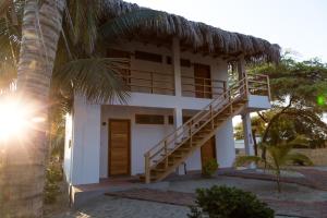 une maison blanche avec un escalier à côté d'un palmier dans l'établissement Olas y Arena, à Vichayito