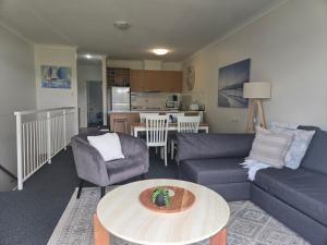 ein Wohnzimmer mit Sofa und Tisch in der Unterkunft Waterfront Hideaway with Pool, Spa & BBQ Area jetty available in Mandurah