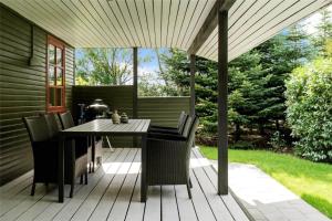 een terras met een tafel en stoelen op een dek bij LF14163-Roslev-Kybehuse-3 in Roslev