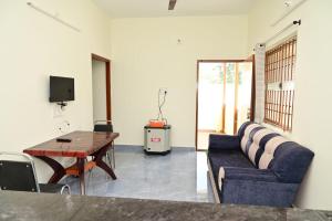 a living room with a couch and a table at Cheenu Cottage in Yelagiri