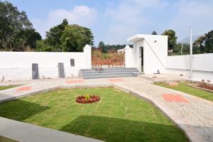 a small garden in front of a white building at Cheenu Cottage in Yelagiri