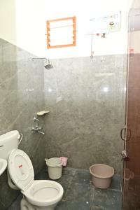 a bathroom with a toilet and a shower at Cheenu Cottage in Yelagiri +5 photos