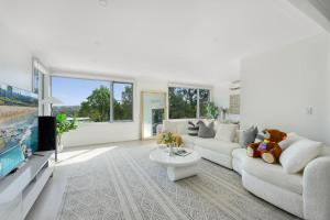 - un salon avec un ours en peluche assis sur un canapé dans l'établissement Self-Contained 3BR Upper-Level Unit Collaroy, à Collaroy 31 autres photos