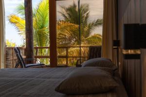 - une chambre avec un lit et une vue sur un palmier dans l'établissement Olas y Arena, à Vichayito