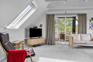 een woonkamer met een flatscreen-tv en een bank bij LF14127-Roslev-Kybehuse-127 in Roslev