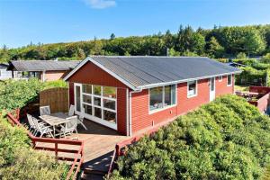 een rood huis met een terras met een tafel en stoelen bij LF11171-Struer-Klintevej-14 in Struer +18 foto's