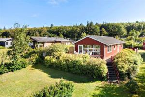 een rood huis op een heuvel met een tuin bij LF11171-Struer-Klintevej-14 in Struer
