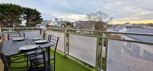 einen Balkon mit einem Tisch und Stühlen sowie Stadtblick in der Unterkunft ESCAPADE FAMILIALE A LA MER in Quiberon
