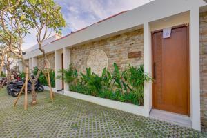 a house with a brick wall and a garage at Bhatara Villa Sanur in Sanur