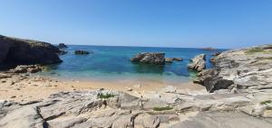 einen Strand mit Felsen und das Meer mit blauem Wasser in der Unterkunft ESCAPADE FAMILIALE A LA MER in Quiberon