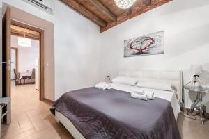 a bedroom with a large bed with two towels at Damiani Appartamenti nel Centro Storico di Palermo in Palermo