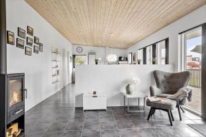 un soggiorno con camino e sedia di LF10202-Thyholm-Markvejen-2 a Thyholm
