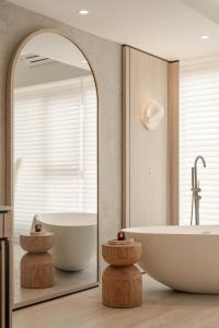 ein Badezimmer mit Badewanne und großem Spiegel in der Unterkunft The Cara Hotel in Kota Kinabalu + 11 Fotos