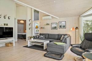 a living room with a couch and a tv at LF10210-Thyholm-Skovstien-10 in Thyholm