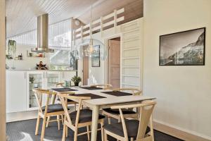 a dining room with a table and chairs at LF10210-Thyholm-Skovstien-10 in Thyholm