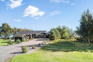 a house with a gambrel roof and a driveway at LF10210-Thyholm-Skovstien-10 in Thyholm