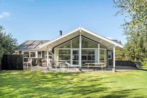 a house with large glass doors and a yard at LF10210-Thyholm-Skovstien-10 in Thyholm +13 photos