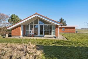 a brick house with large windows on a field at LF10229-Thyholm-Skovstjernevej-9 in Thyholm