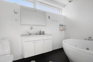 a white bathroom with a sink and a tub at LF10214-Thyholm-Havnefronten-14 in Thyholm +25 photos