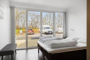 a bed in a room with a large window at LF10214-Thyholm-Havnefronten-14 in Thyholm
