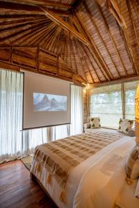 een slaapkamer met een groot bed in een kamer met ramen bij Moonlit Jungle in Seribatu +83 foto's