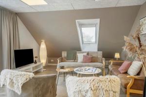 een woonkamer met een bank en een tv bij LF10301-Hurup-Thy-Sindrupvej-1-B in Sindrup