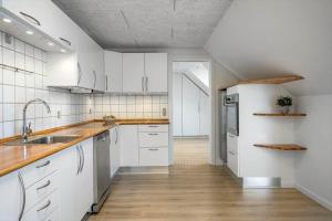 een keuken met witte kasten, houten vloeren en een spoelbak bij LF10301-Hurup-Thy-Sindrupvej-1-B in Sindrup +11 foto's
