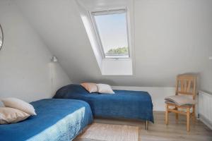 een zolderslaapkamer met twee bedden en een raam bij LF10301-Hurup-Thy-Sindrupvej-1-B in Sindrup