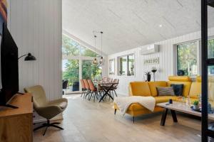 een woonkamer met een gele bank en een tafel bij LF11106-Struer-Slugten-6 in Humlum