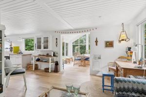 een keuken en woonkamer met een tafel en stoelen bij LF18116-Veslos-Agerovej-6 in Amtoft