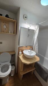 een badkamer met een wastafel, een toilet en een spiegel bij Val Thorens Centre, Kino Duplex, 34m2, 5-6 personnes in Val Thorens