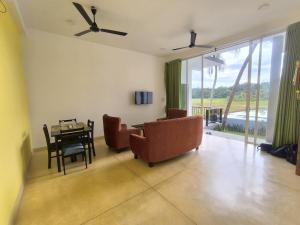 a living room with a couch and a table and chairs at Oasi house in Unawatuna