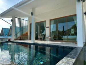 une maison avec piscine à côté d'une maison dans l'établissement Sunsea Resort, à Baan Khai
