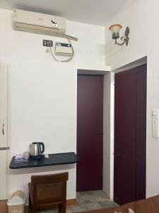 a kitchen with two purple doors and a stove at Varson Stay in Pondicherry