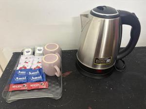 a coffeemaker and a tea kettle on a counter at Varson Stay in Pondicherry