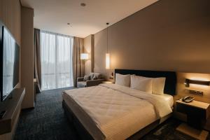 乌拉尔斯克West Plaza Hotel的一间配有床和电视的酒店房间 更多23张照片