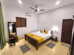 a bedroom with a large bed and a mirror at Oasi house in Unawatuna
