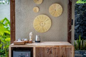 a wooden counter with four plates on a wall at Moonlit Jungle in Seribatu