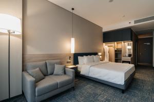 a hotel room with a bed and a chair at West Plaza Hotel in Oral