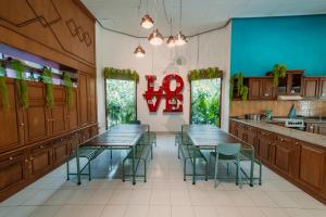 een restaurant met tafels en stoelen in een keuken bij Snooze Malang in Malang