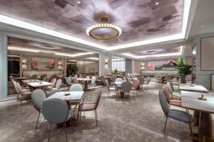 a restaurant with tables and chairs and a ceiling at Mercure Chengdu Dongjiao Memory in Chengdu