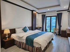 een slaapkamer met een groot bed en een bureau bij SAPA COSY HOTEL in Sa Pa