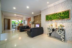 un soggiorno con un divano e un muro di mattoni di Danka Taman Golf Residence a Kangboi