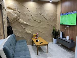 a room with a tv and a couch and a table at Дачный дом in Balqash
