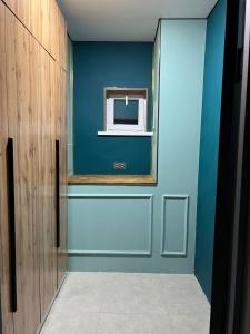 a hallway with a blue wall and a mirror at Дачный дом in Balqash