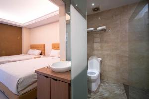 bagno con 2 letti, lavandino e doccia di Danka Taman Golf Residence a Kangboi Altre 38 foto